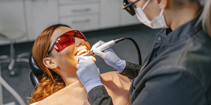Cosmetic dentist performing gentle laser gum contouring treatment on a patient in a modern San Diego dental office