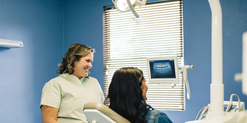 Calm dental office scene with patient in comfortable chair and dentist monitoring vital signs