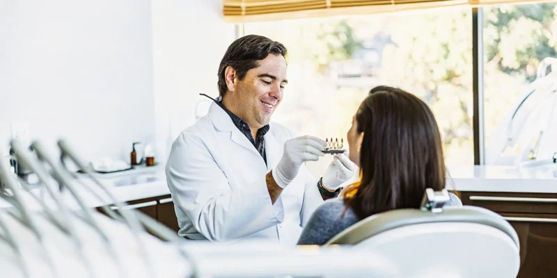 Dentist consulting with a patient about a custom mouth guard for teeth grinding in a modern San Diego dental office